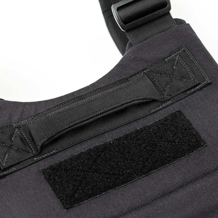 Close-up of the GORUCK Training Weight Vest in black, showcasing a handle and Velcro patch on the fabric surface.